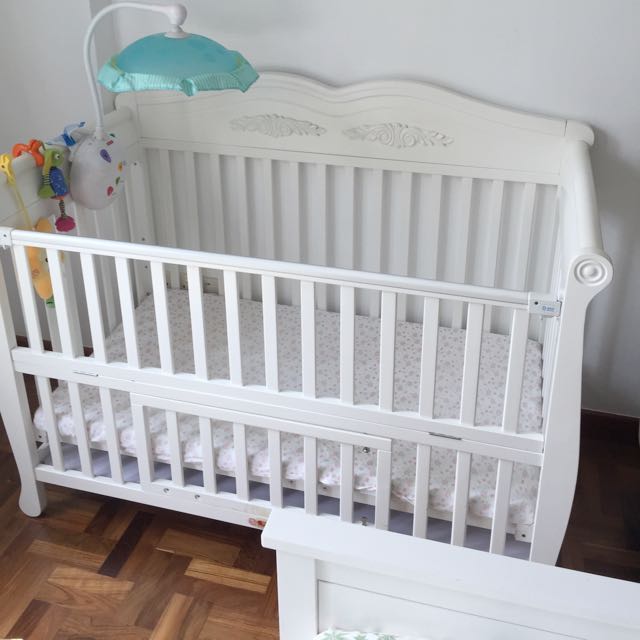 white wooden baby cot