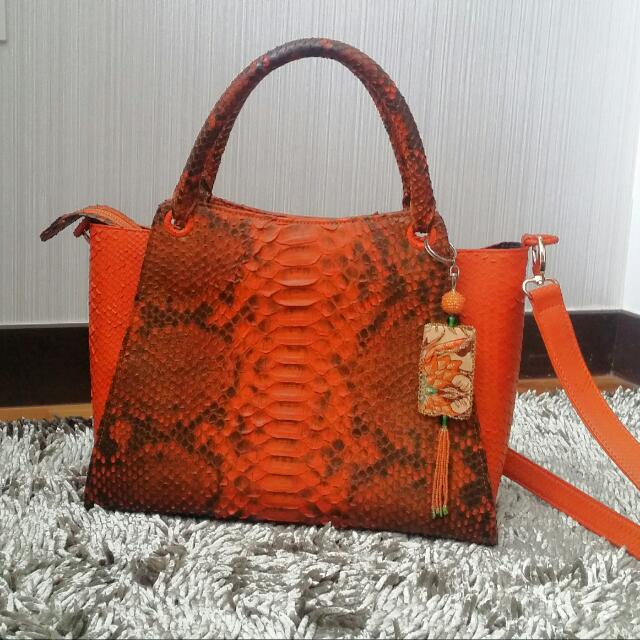 Genuine Python Leather Bag (Category: Cross-body Bags) located in Singapore. Submitted by gitatan (Listing ID 90317946, Image 1). Description: Size: HxWxL(cm) 25×15×35. Orange color Condition 9.5/10. Good Quality hand made pyhthon bag. With a sling strap (L 100 cm) .