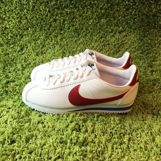 white nike shoes with red tick