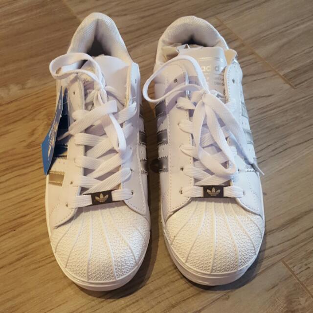 white adidas with silver stripes