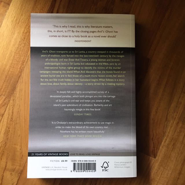 A worn paperback copy of Anil's Ghost, its cover slightly creased, representing the passage of time and the enduring impact of trauma.