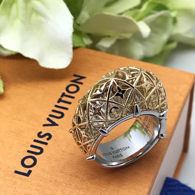 A LOUIS VUITTON LUCITE AND GOLD LEAF RING, the bombe style clear coloured  ring inset with gold leaf details including initials LV and flowerhead  details. In Louis Vuitton box. Ring size N.