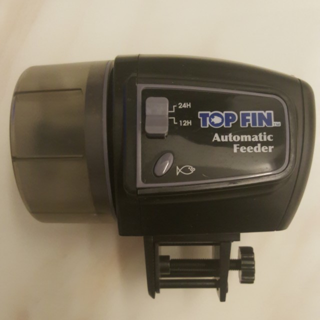 Top fin automatic feeder outlet