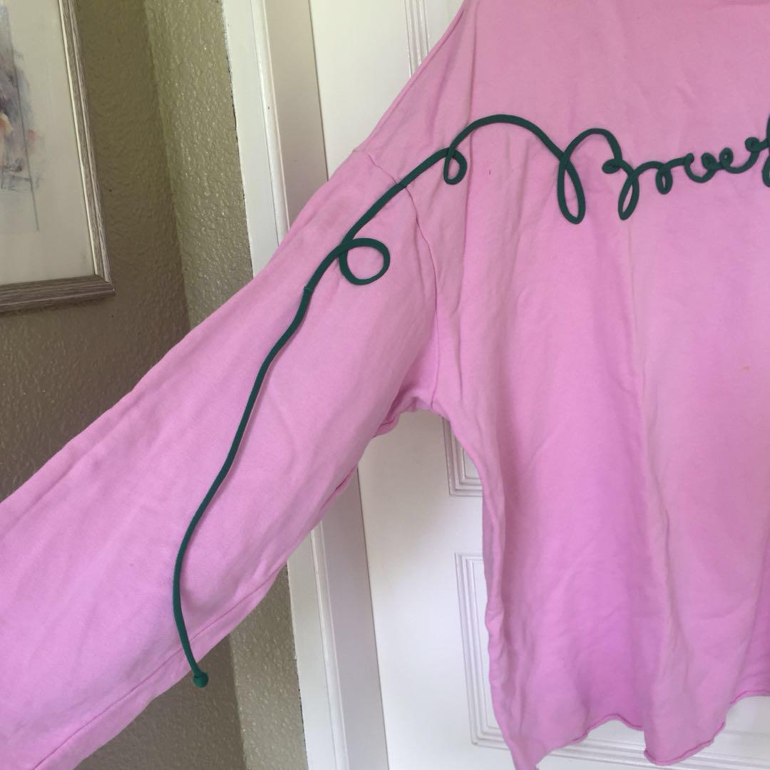 Pink jumper 2025 green writing