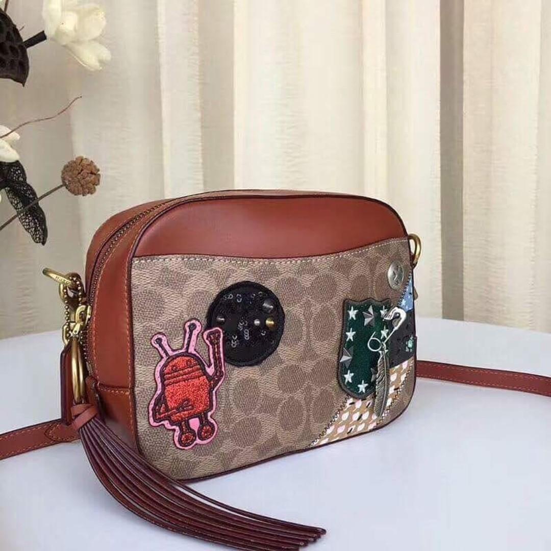 Authentic Coach X Keith Haring Camera Bag In Signature Patchwork - Khaki (Category: Cross-body Bags) located in Bacoor. Submitted by littlebagmanshop (Listing ID 193913622, Image 2). Description: This bag features works from artist Keith Haring, combining his iconic illustrations with Coach's signature craft and all-American attitude. Designed in Signature canvas, the simple silhouette is detailed with the artist's motifs and Americana quilting. 
