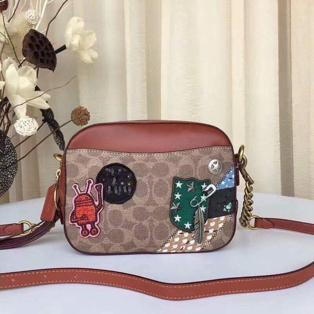 Authentic Coach X Keith Haring Camera Bag In Signature Patchwork - Khaki (Category: Cross-body Bags) located in Bacoor. Submitted by littlebagmanshop (Listing ID 193913622, Image 1). Description: This bag features works from artist Keith Haring, combining his iconic illustrations with Coach's signature craft and all-American attitude. Designed in Signature canvas, the simple silhouette is detailed with the artist's motifs and Americana quilting. 