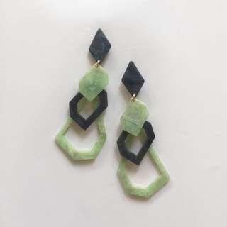 Earrings in green, black, brown, and taupe