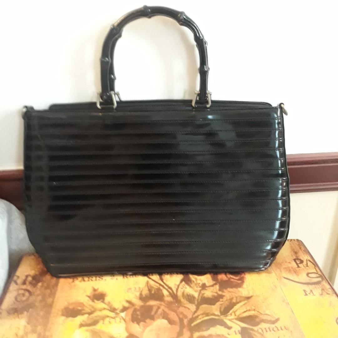 Unique document bag (Category: Tote Bags) located in Singapore. Submitted by debbiely2006 (Listing ID 199190164, Image 1). Description: Leather document bag in good condition with pin-tuck sewing and bamboo handles. Rare design..