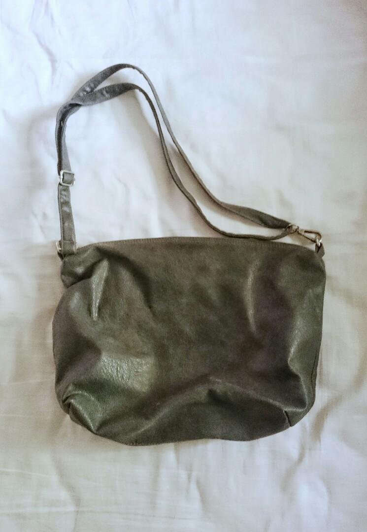 Gray Sling Bag (Category: Cross-body Bags) located in Quezon City. Submitted by mallows23 (Listing ID 203796334, Image 1). Description: Good used condition With zipper and one pocket on the interior Rfs: Decluttering Additional shipping fee.