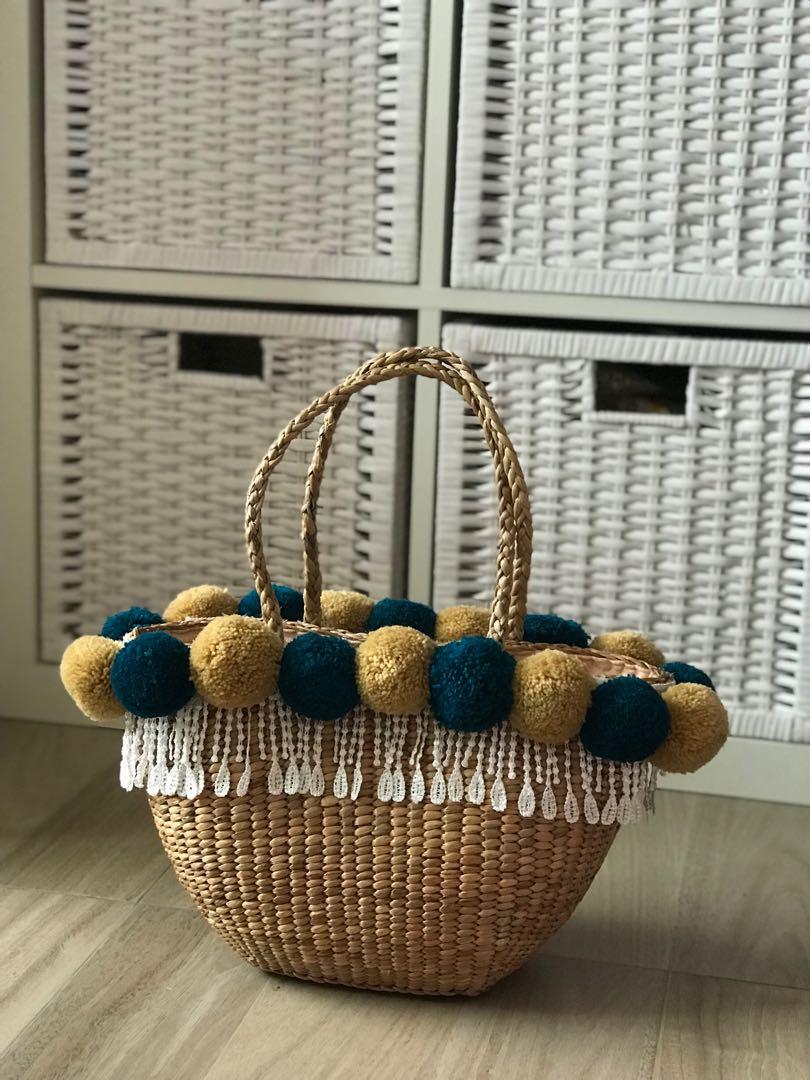 straw handbag with pom poms