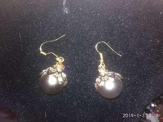 Dangling gold pearl earrings with gemstone