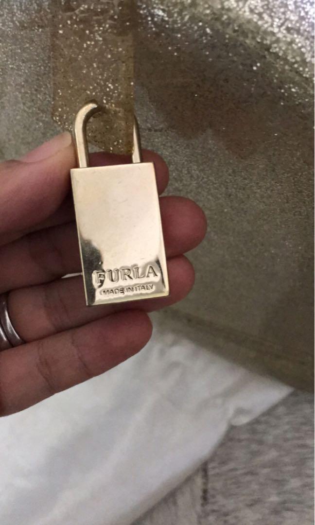 Authentic Furla sparkly gold jelly bag (Category: Luxury Bags & Wallets) located in Mandaluyong City. Submitted by karlapatricia01 (Listing ID 229478708, Image 2). Description: Limited edition furla in sparkly gold color. Lock and dust bag included. Retails for P17,500.00 Small tear at the end of the zipper which is common with jelly bags but not noticeable when worn..