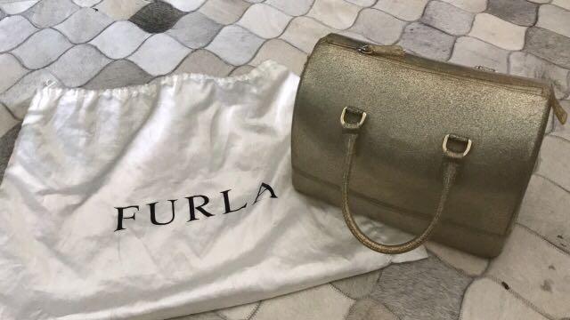 Authentic Furla sparkly gold jelly bag (Category: Luxury Bags & Wallets) located in Mandaluyong City. Submitted by karlapatricia01 (Listing ID 229478708, Image 1). Description: Limited edition furla in sparkly gold color. Lock and dust bag included. Retails for P17,500.00 Small tear at the end of the zipper which is common with jelly bags but not noticeable when worn..