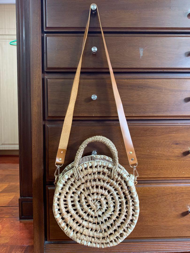 Elinora PH round rattan bag (Category: Beach Bags) located in Makati City. Submitted by _stepau (Listing ID 230748310, Image 3). Description: Round rattan bag from Elinora PH, with a detachable brown leather trap and snap closure. Bought last 2017 but never used, just stored. Bought for somewhere between Php1800-1950. RFS: Never got to use it.