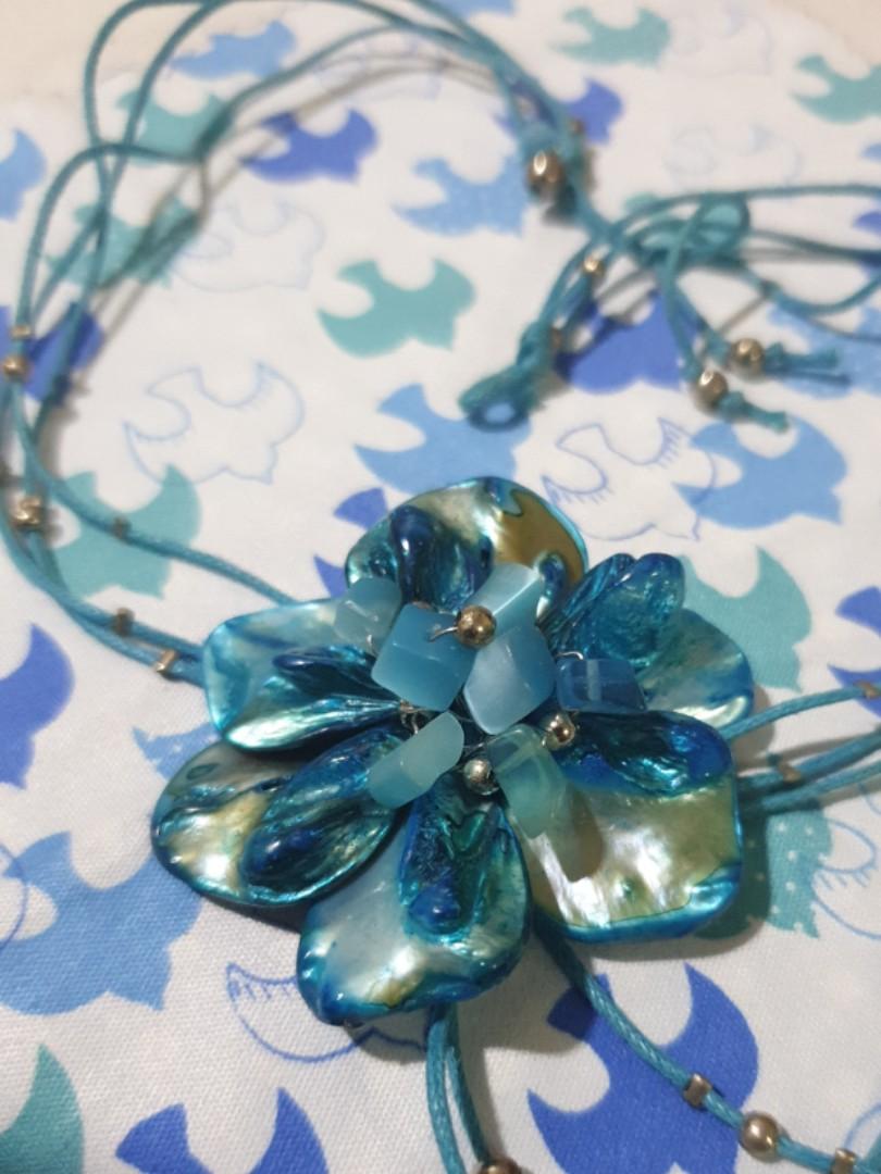 Turquoise-colored Flower Necklace (Category: Necklaces) located in Quezon City. Submitted by daaaaane (Listing ID 241215315, Image 1). Description: An aqua blue necklace featuring a six-petal flower with a mother-of-pearl finish. Secured by a loop and a silver bead on the back. The flower is held together by silver wires threaded through each petal. I might've worn this for my debut. Might've. Di ko na 100% maalala eh. 😂😂😂.