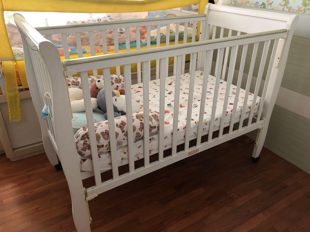 white wooden baby cot
