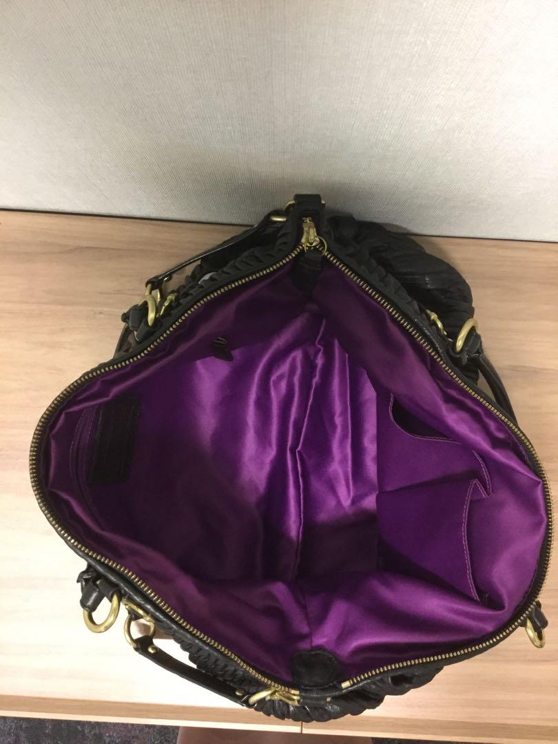 black coach purse with purple lining