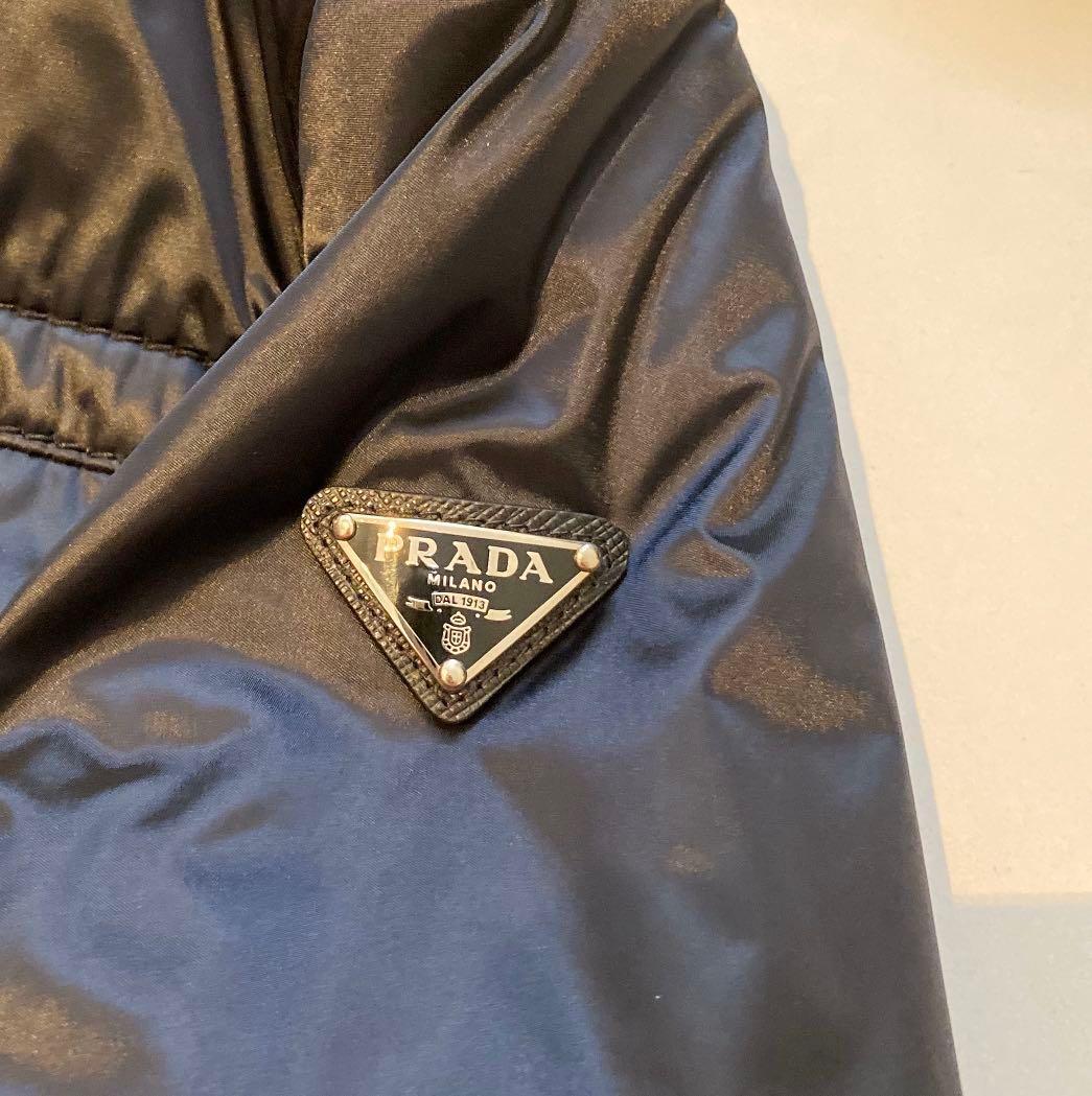 PRADA Down Jacket (Category: Apparel) located in Singapore. Submitted by ts2008 (Listing ID 257527920, Image 3). Description: ITEM ON HOLD till June 2024 100% Authentic Colour: Navy/Blue Conditions: like new (but some scratches on zipper pull Style: Hooded down Jacket with 2 inner and outer pockets. Light weight Pls refer to last photo for measurements. Bought from Japan Gotemba . Comes with original receipt and product tag .