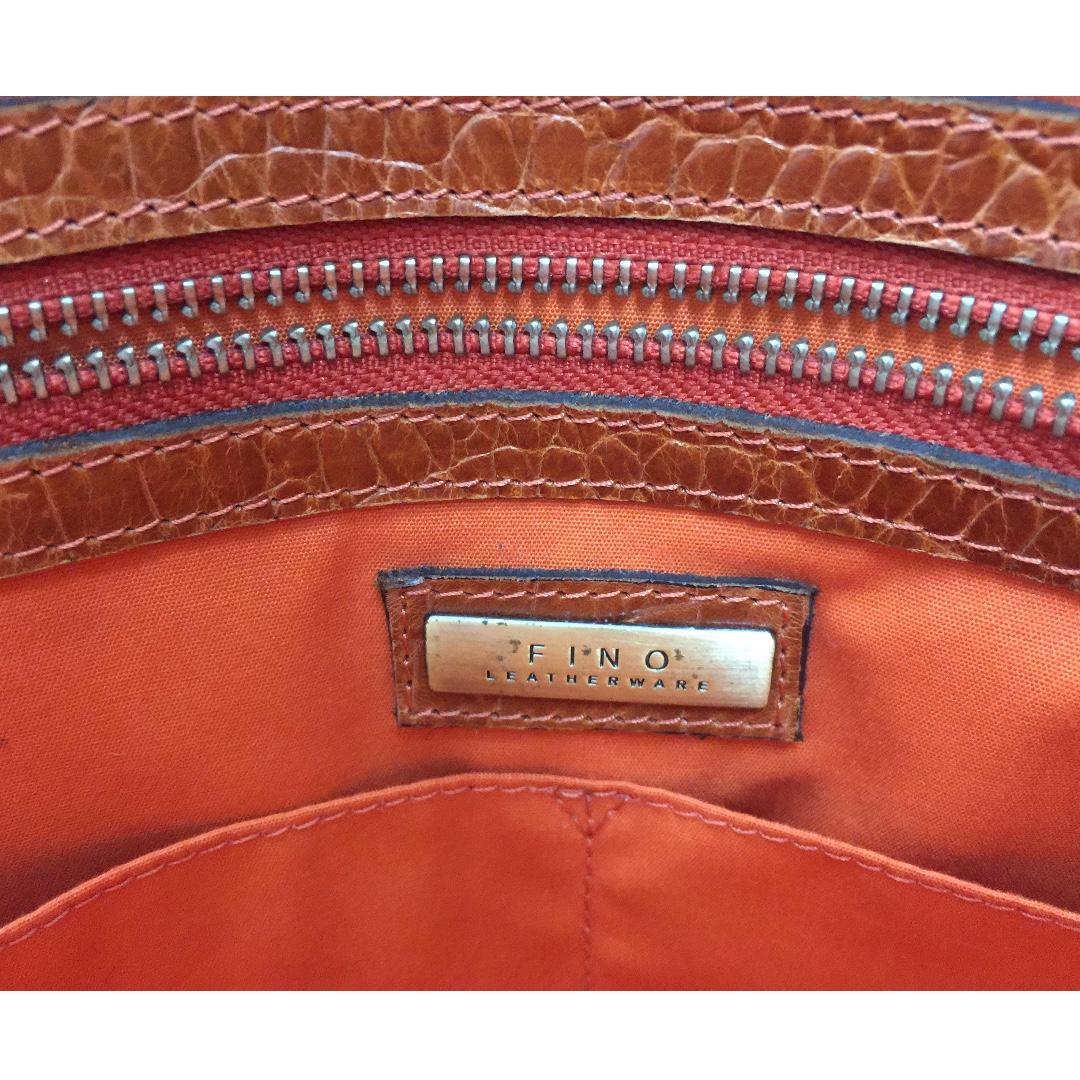 FINO Leather Handbag (Category: Tote Bags) located in Manila. Submitted by ina_44 (Listing ID 264555025, Image 3). Description: Dark Orange/Tan FINO Leather Handbag with black case as seen in picture. TEXT ONLY FOR INQUIRIES.