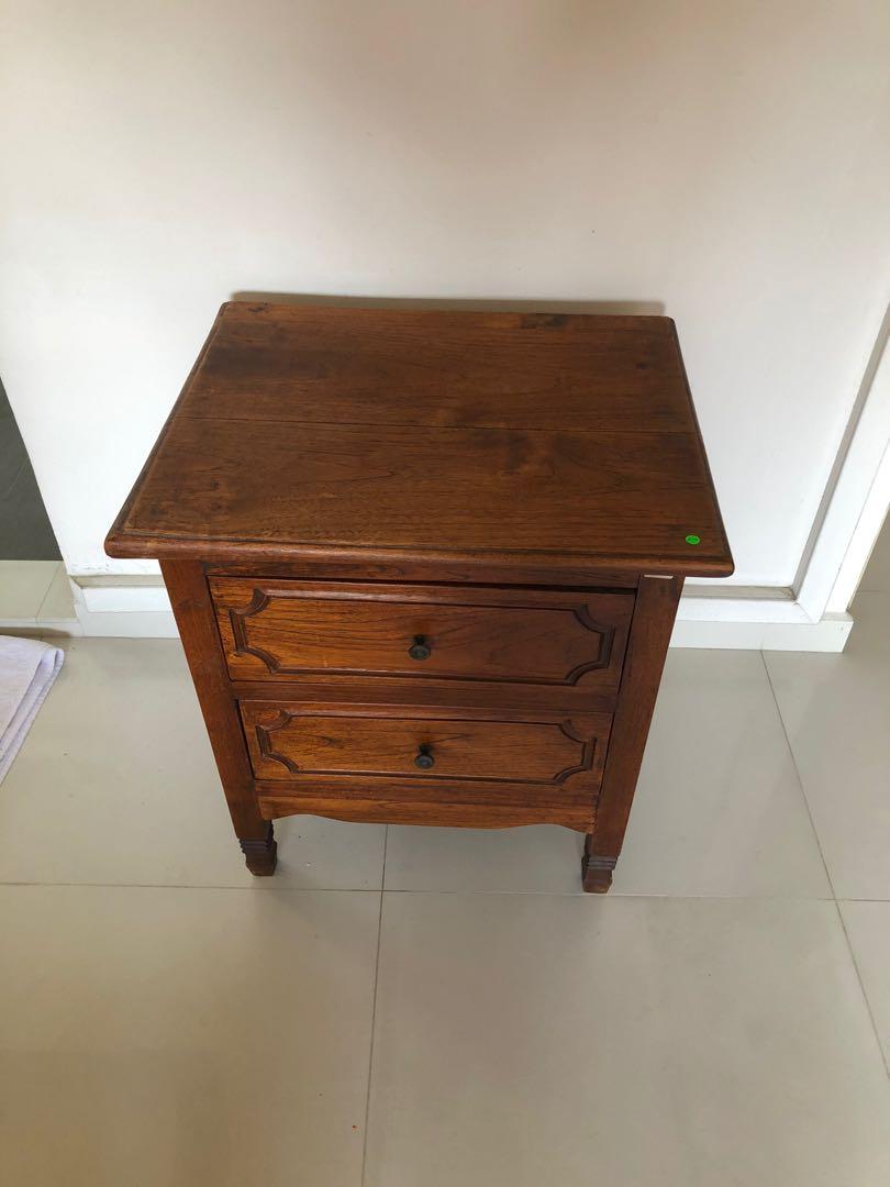 Bedside or Side Table (Category: Tables & Sets) located in Singapore. Submitted by esing2020 (Listing ID 1005997341, Image 1). Description: Solid teakwood bedside or side table w two drawers still in stable and good condition except for a line crack on the top panel and at the side as well. Clearance sale, good buy for daily use! Dimension: L = 56 cm, B = 44 cm and H = 63 cm.