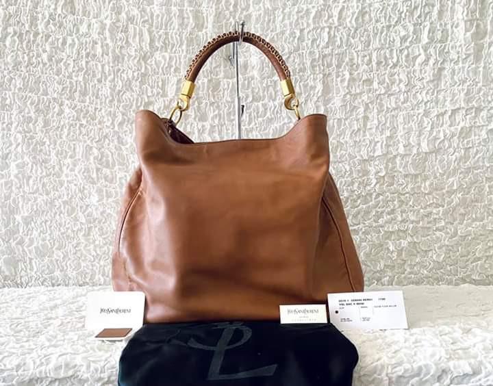 Saint Laurent Roady Hobo (Category: Luxury Bags & Wallets) located in Carmona. Submitted by bagislifeshop (Listing ID 1019846564, Image 1). Description: 98%New Caramel brown lambskin leather Satin silk inside lining Matte good hardware Dimensions-15”x14”x6.5” Handle drop-8” Good as new, mint condition Comes w/ tag, card, dustbag And leather swatch.