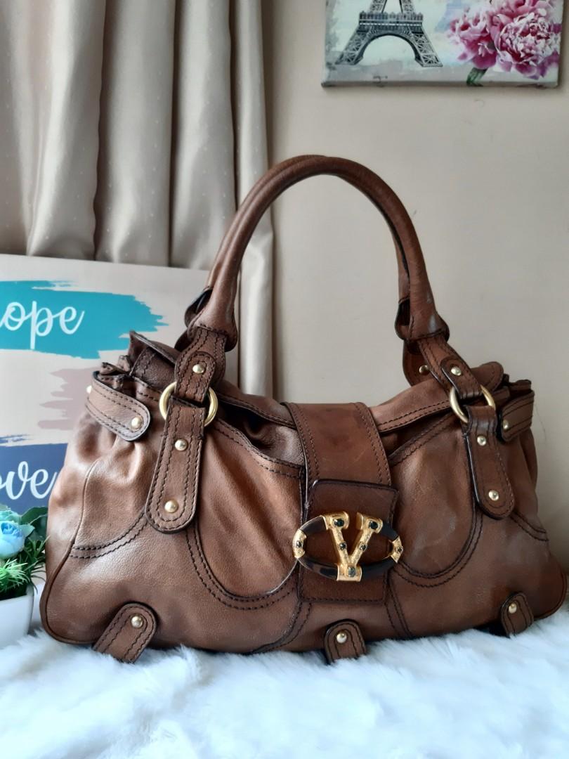 Vintage Valentino Garavani (Category: Luxury Bags & Wallets) located in Pasig City. Submitted by dual_time (Listing ID 1128356179, Image 2). Description: Vintage Valentino Garavani Handbag Authentic used, in good condition issues: - chipped rock on right side of V - dark discoloration onlock due to use - missing zipper head inside Price negotiable RFS: Decluttering item location: Manggahan, Pasig.