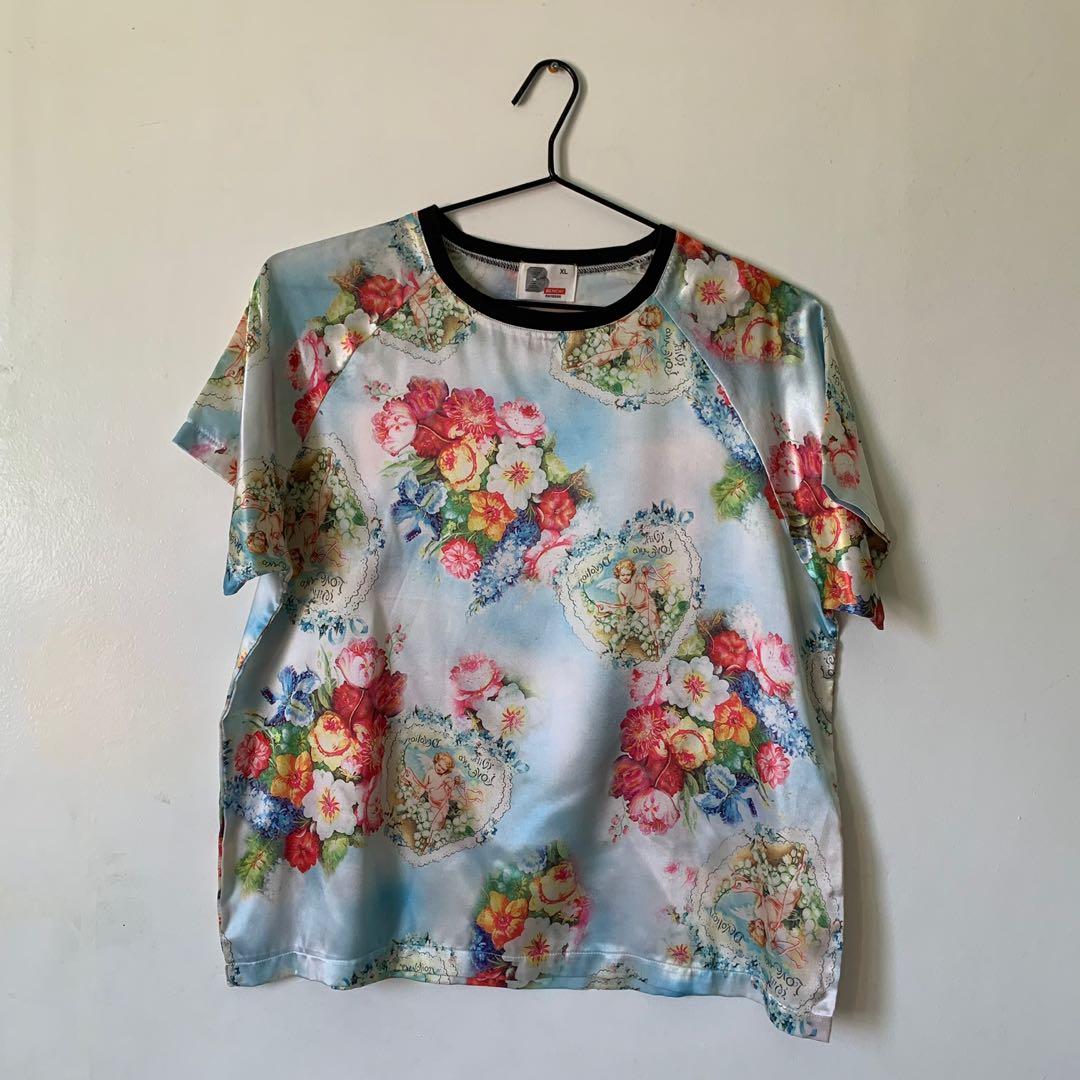 Bench Satin Printed T-Shirt (Category: Blouses) located in Mandaluyong City. Submitted by yeontsuki (Listing ID 1130290568, Image 1). Description: Overall printed cherub shirt! Satin so presko sya!.