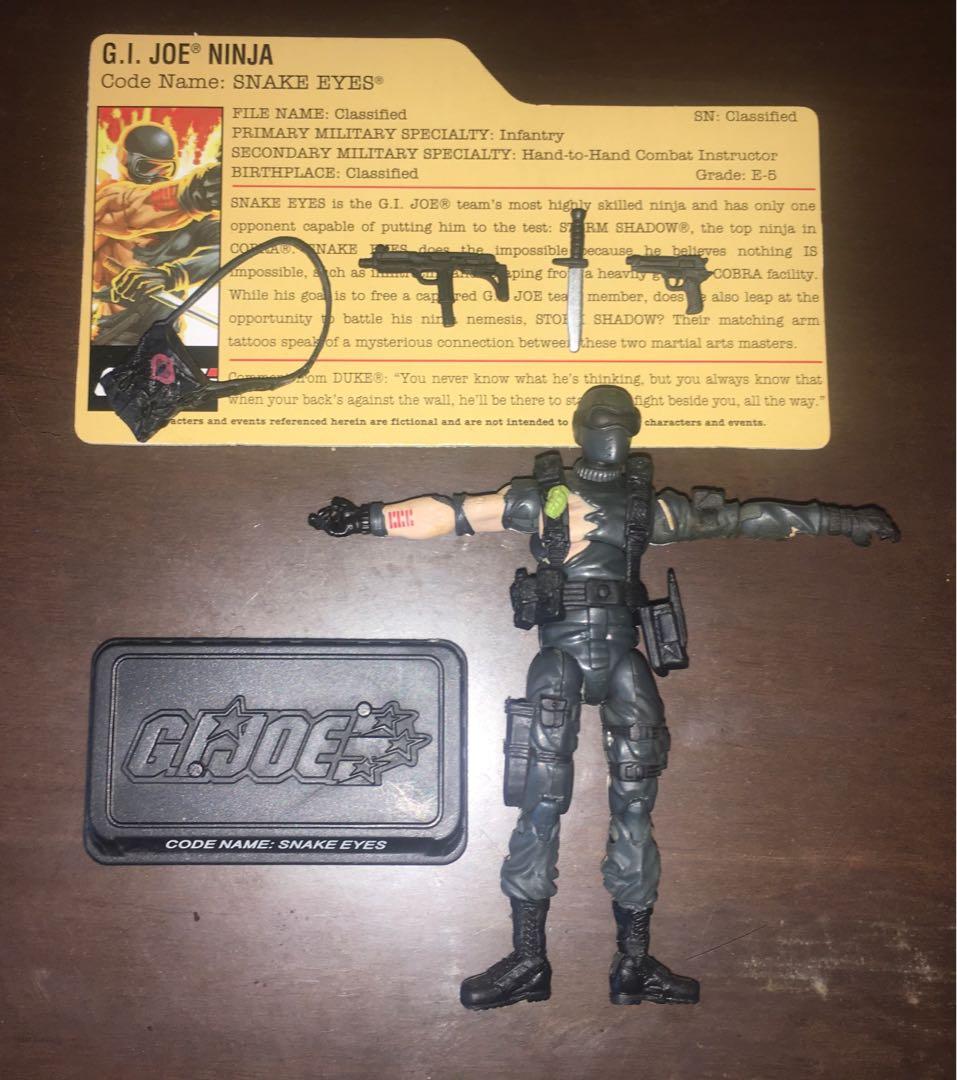 GI G.I. JOE TFAC BATTLE DAMAGED COMMANDO SNAKE EYES (Category: Action & Battle Toys) located in Makati City. Submitted by tudortiger2000 (Listing ID 1085176202, Image 3). Description: G.I. JOE 25th ANNIVERSARY COLLECTION (TFAC) BATTLE DAMAGED COMMANDO SNAKE EYES Hasbro 2008, Version 32 Comic pack with Storm Shadow (ver. 25) Accessories: - removable webgear - satchel - uzi submachine gun - pistol - dagger - character filecard - figure stand with n