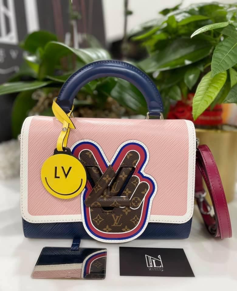 V for Vuitton morphs into a peace symbol on this Twist MM handbag. The  motif is crafted from Mini Monogram canvas, which also cov…