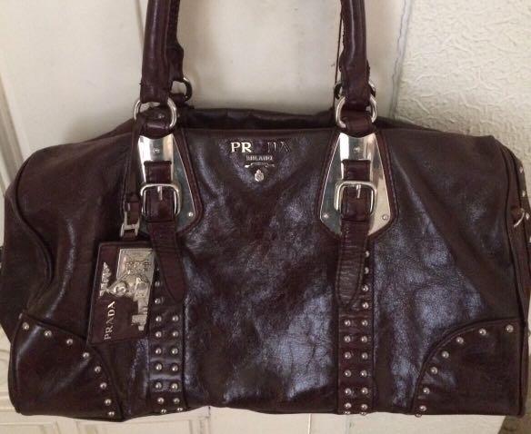 Prada talco Bauletto leather bag (Category: Luxury Bags & Wallets) located in Paranaque City. Submitted by jd555 (Listing ID 1103688718, Image 1). Description: prada talco bauletto Trunk style studded bag Made in Italy Pre-loved Color brown Size H 10” W 15” B 6” Inclusions- padlock & key Hangtag dust bag Coded Lampo zipper Black jacquard prada signature lining Flaws: Missing letter A in prada And shoulder strap Sold as is No other inclusion Payme