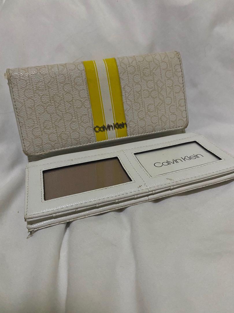Calvin Klein Authentic Three-fold Monogram Wallet (Category: Wallets & Card holders) located in Makati City. Submitted by sheishops (Listing ID 1099013725, Image 2). Description: Brand: Calvin Klein Design: Monogram three-fold Color: White (body), yellow (accents) *Used once only There’s a bit of a damage as seen in photos Reason for selling: Owner does not use it. Stuck in a drawer..
