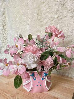 Pink diaper vase with artificial flowers