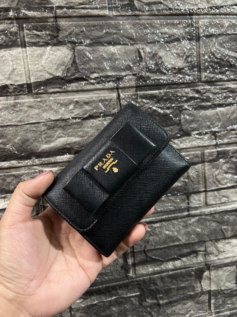 Prada Saffiano Small Fiocco Bow Wallet (Category: Luxury Bags & Wallets) located in Paranaque City. Submitted by sillybella (Listing ID 1195954605, Image 1). Description: Lower Shipping fee check out c/o orange app Japan Bought 100% legit Prada Saffiano Small Fiocco Bow Wallet Color: Nero / Black No inclusion selling low Exterior: Edge wear Hardware: minor Scratch(es) / fading Interior: normal surface wear Length: 4.75 in Width: 0.75 in Height: 3