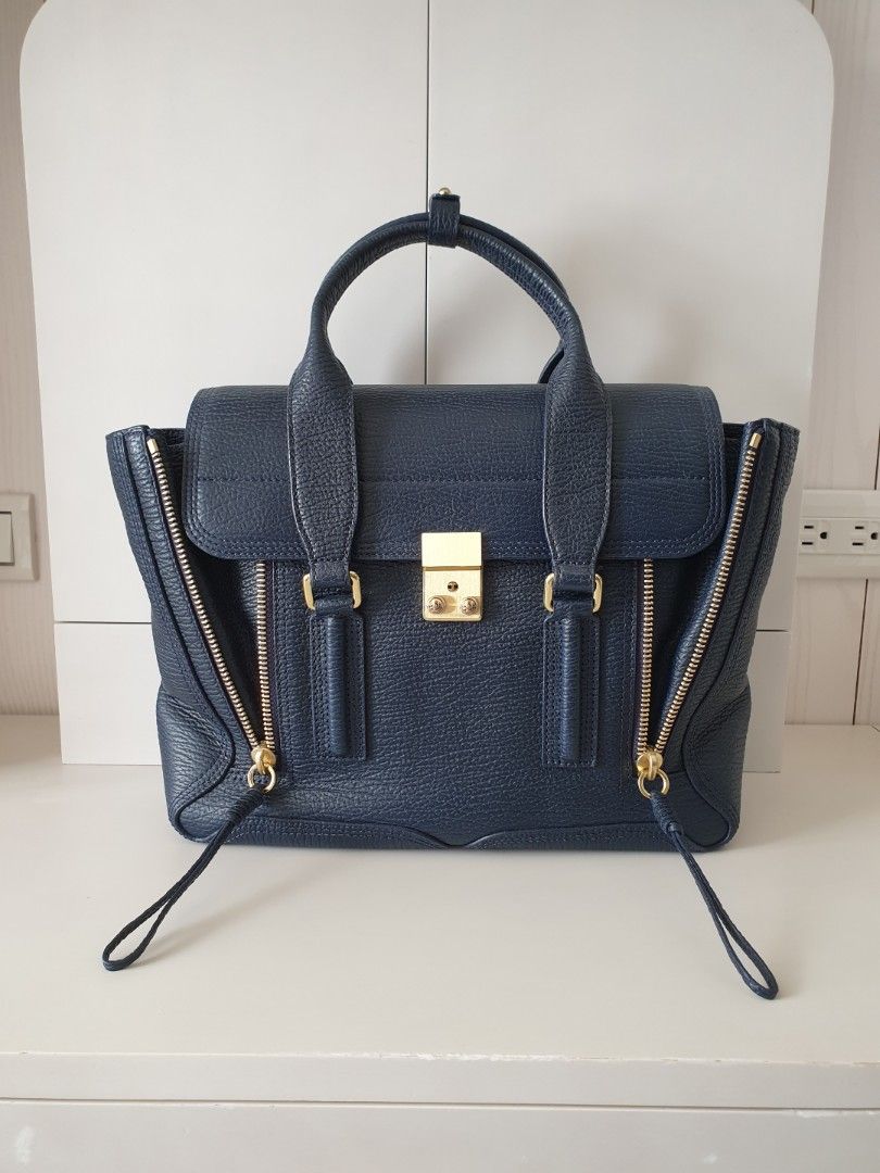 由 rainie_little (刊登 ID 283181672，圖片 1) 提交，位於 台北市 (Taipei) 的 3.1 Phillip Lim Pashli Medium Satchel Navy壓紋牛皮兩用手提肩背包深藍 男女皆可用 (類別：精品包與皮夾)，說明：- 尺寸25X32X10cm，可放A4 - 檢查有點瑕疵請見最後四張圖 - 用過兩次，幾乎全新 - 用習慣小包幾乎沒有在背，保護的非常好 - 新加坡專櫃購入新幣1330約台幣30000，絕對正品 - 配件都有附，只是收據已遺失。