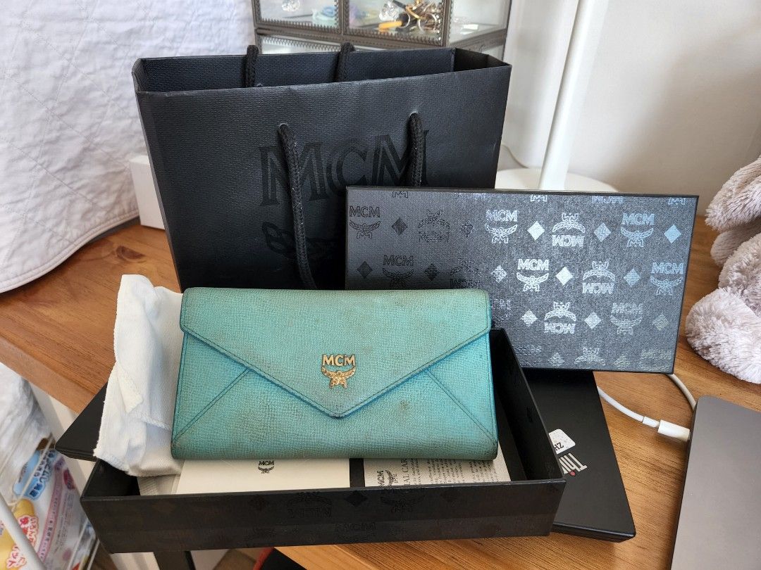 MCM long wallet blue. Box bag dust bag cards (Category: Bags & Wallets) located in Singapore. Submitted by hatsuyuki26 (Listing ID 1198329672, Image 1). Description: Well used MCM wallet Will need some cleaning Comes with full set of bag, box, dust bag, cards 100% authethic Free courier or meet up.