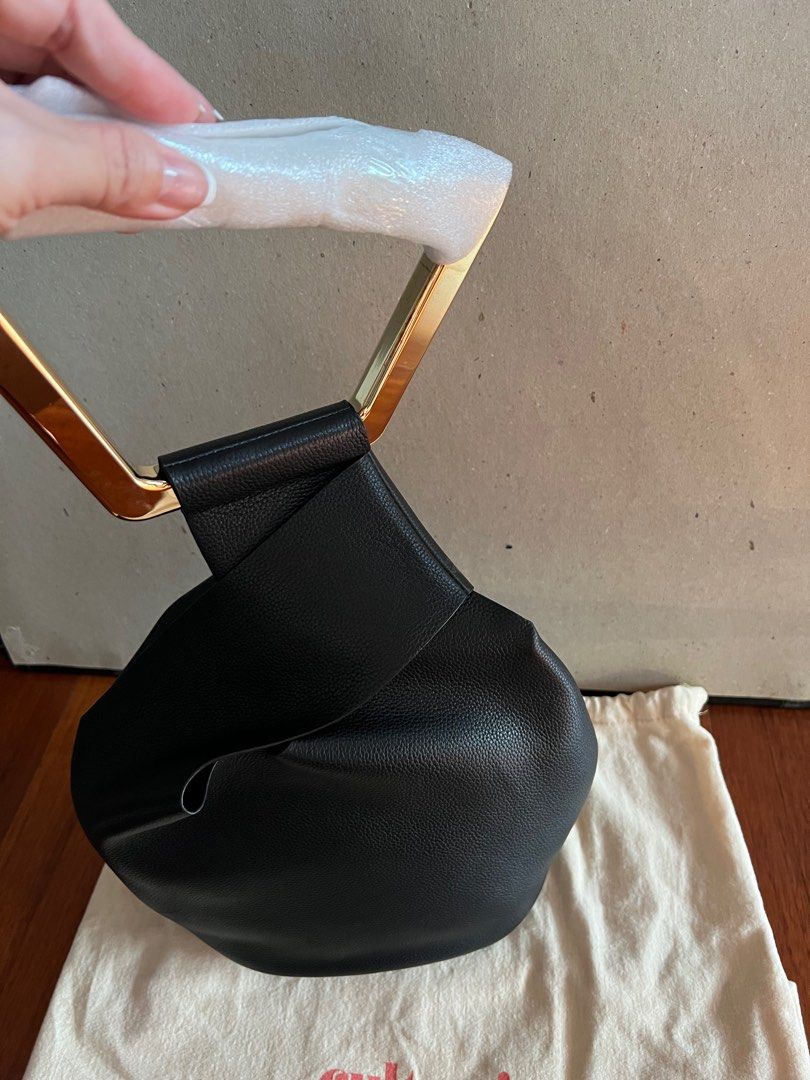 Cult Gaia Astraea Bag (Category: Luxury Bags & Wallets) located in Muntinlupa City. Submitted by bagstagram (Listing ID 1198543420, Image 3). Description: Complete inclusions Unused Cult Gaia’s founder and creative director, Jasmin Larian, became a mother and needed a more practical bag that was still chic and stylish, and that is how she came up with the Astraea tote. The handle loops around the metal handle for closure, providing a unique desig