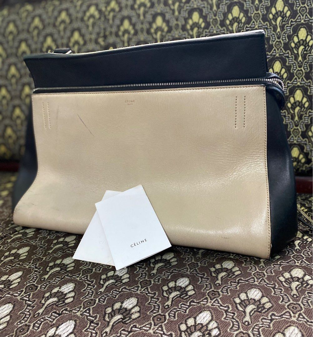 Celine Edge Leather Bag (Category: Luxury Bags & Wallets) located in Pasig City. Submitted by offthemetro (Listing ID 1199507509, Image 2). Description: Pre-owned Authentic Celine Edge Bag Leather in taupe and black leather. This bag features an exterior back pocket, single looped shoulder strap, gold stamped Celine logo, protective base studs and silver-tone hardware accents. Its large zip-around closure opens to a black leather-lined interior w