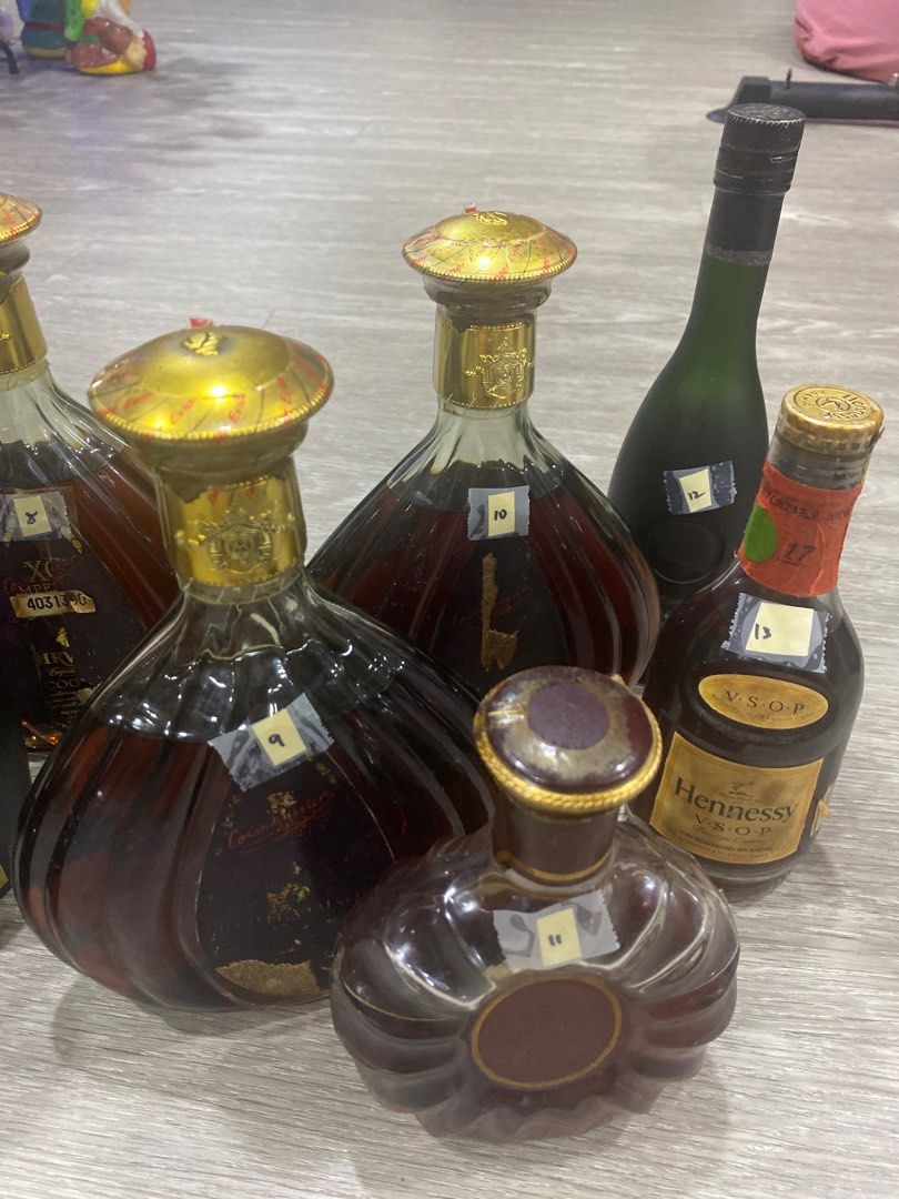A display of various brandy bottles beside a steaming pot of eggnog