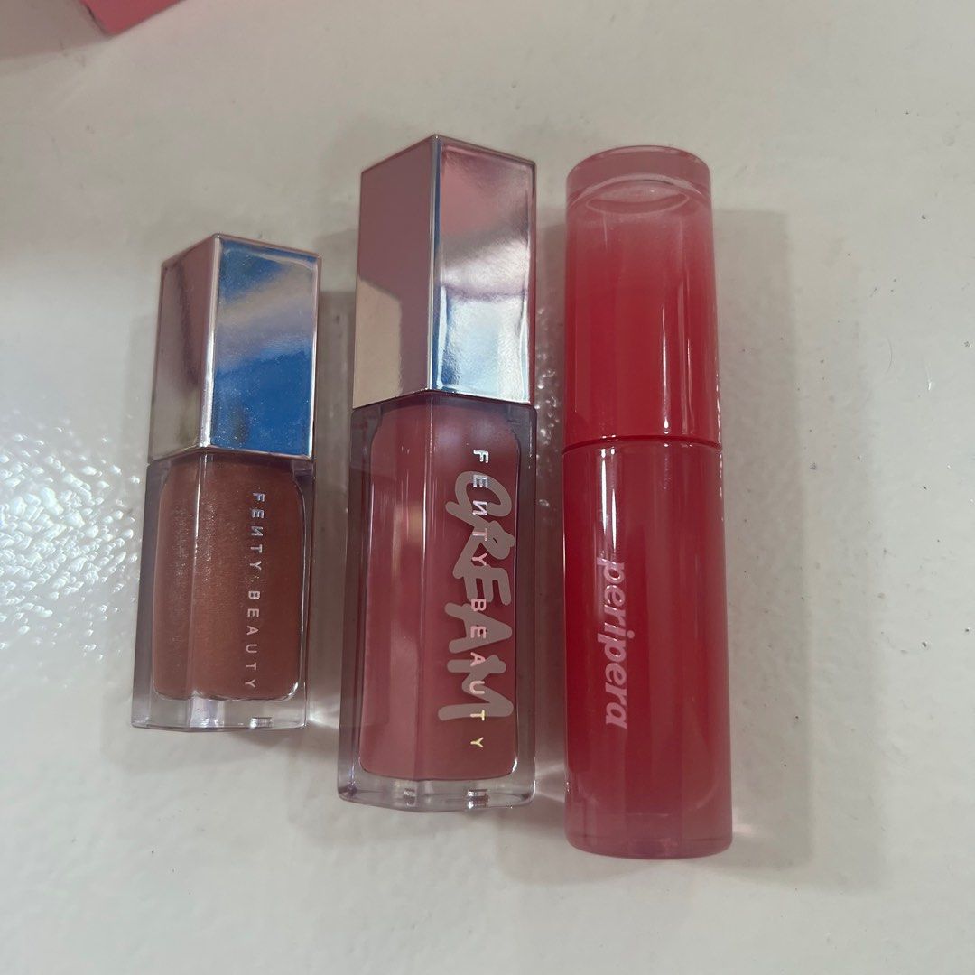 Fenty Beauty Gloss x Peripera (Category: Makeup) located in Paranaque City. Submitted by chinitamaria (Listing ID 1200259555, Image 2). Description: Set of 3 na po makukuha nyo for almost a price of 1 fenty gloss. - fenty gloss bomb cream shade: cupcakin’ - fenty gloss lumi shade: fenty glow mini size and may konti discoloration sa cap - peripera ink mood tint shade: cherry so what -brandnew po yung 3 but all swatched once lang. - yung 2 fenty wa