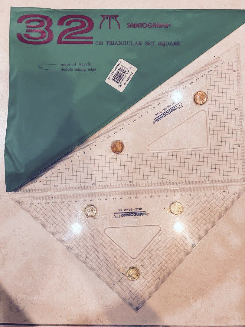 32cm triangular set square (Category: Craft Supplies & Tools) located in Singapore. Submitted by happyfibs (Listing ID 1202305691, Image 1). Description: As per photo Used 1 or 2 times The coins are attached so that the ruler will not touch the paper and smudges your artwork. Can be removed. Can throw in a 30cm metal ruler if you need Let me know .