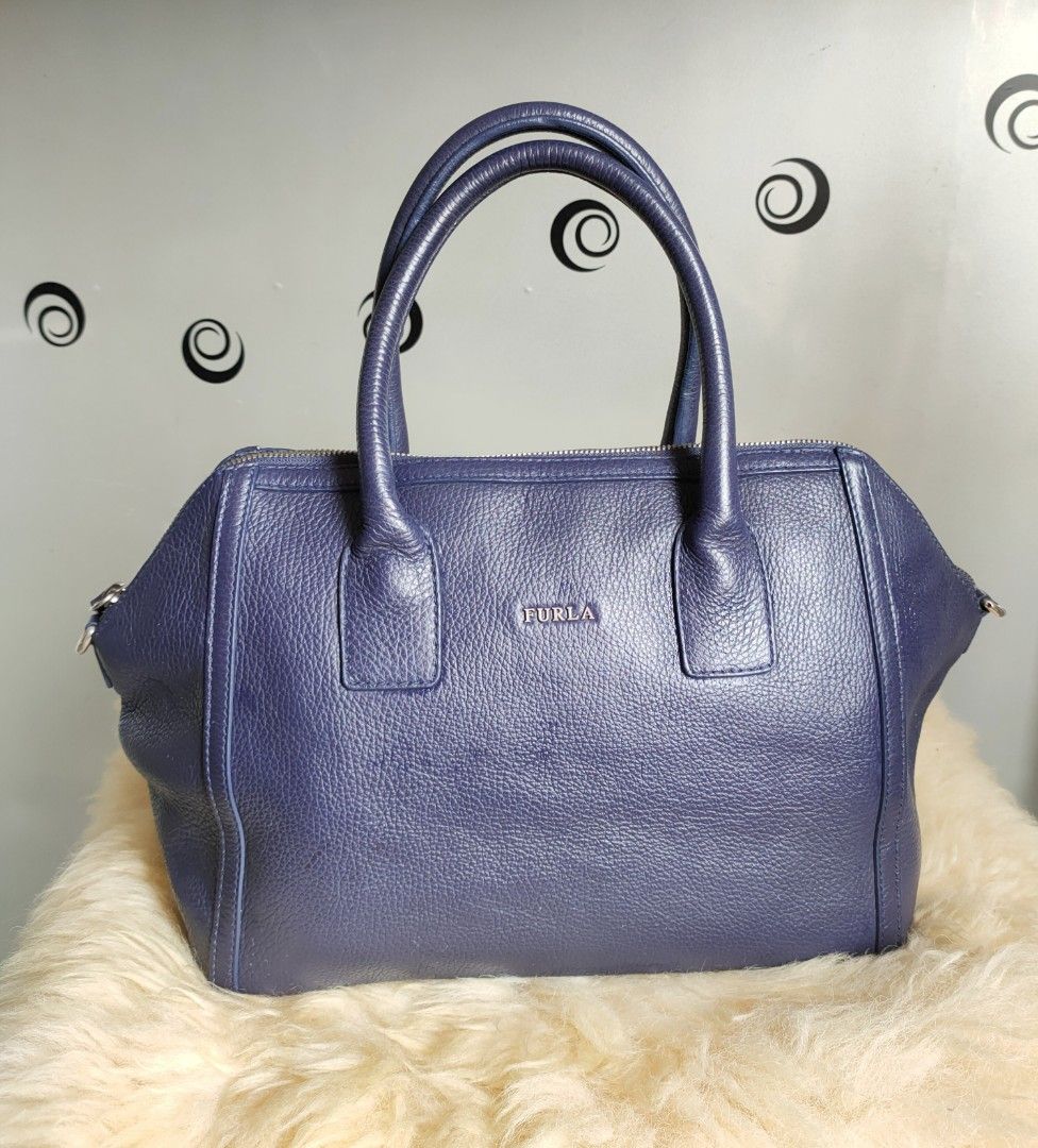 FURLA Satchel/ Top Handle Bag (Category: Luxury Bags & Wallets) located in Tuguegarao City. Submitted by roab_ (Listing ID 1202935880, Image 1). Description: Color: Blue Material: Pebbled leather/ silver tone hardware 🔸 Top zip closure 🔸 Double wrapped leather handles and shoulder strap with a 38 inches long strap. 🔸 Dimensions: 16"L (across top) 12"L (across bottom) X 9.5"H X 6"W. 🔸 Last price posted. 🔸 I ship fast. 🔸Shipping/delivery fee 