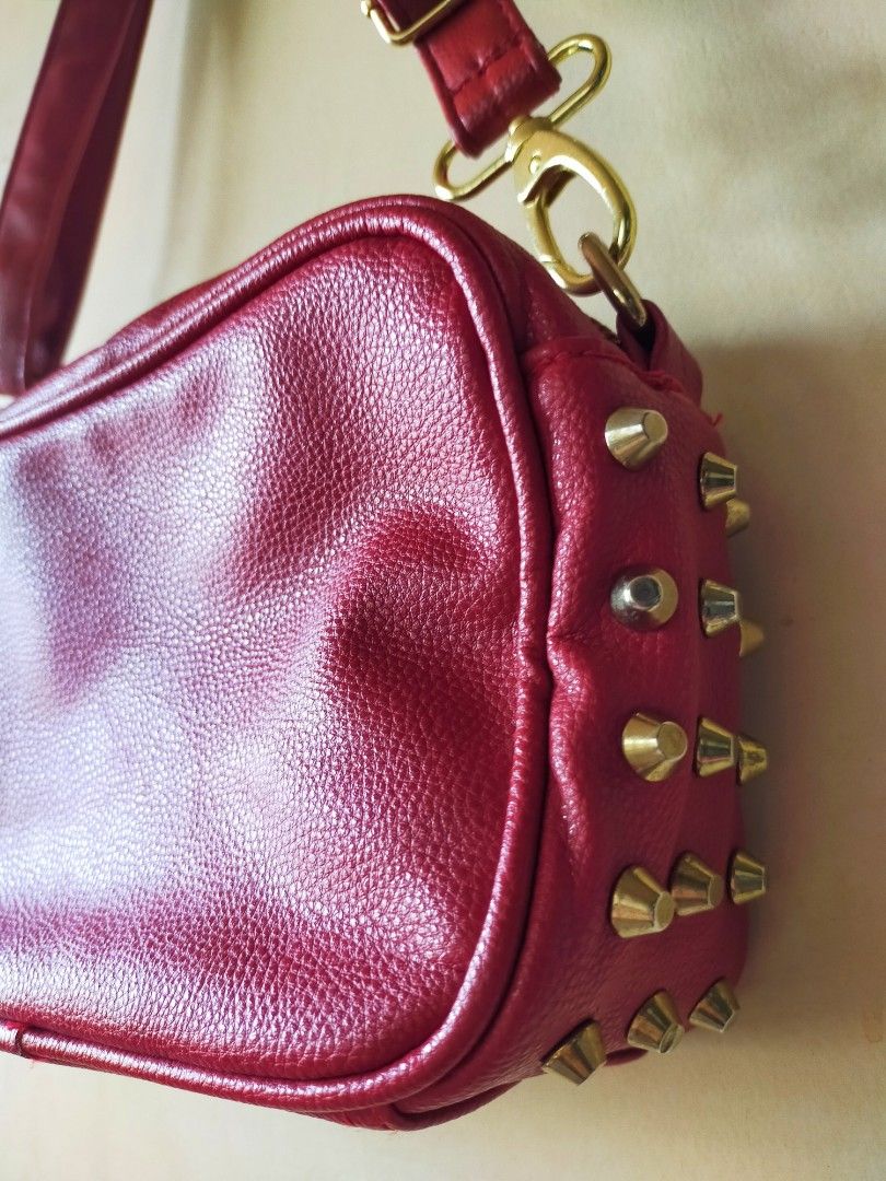 Red Leatherette Cross-body Sling Bag with Studs (Category: Cross-body Bags) located in Tanza. Submitted by lessmess.ph (Listing ID 1200710245, Image 3). Description: Red Leatherette Cross-body Sling Bag with Studs • Preloved and in good condition • With detachable and adjustable strap (buckles were replaced) • Has studded detail on sides and 1 exterior pocket with zipper • Has 2 pockets on the inside - one with zipper and one without • Approx. 24