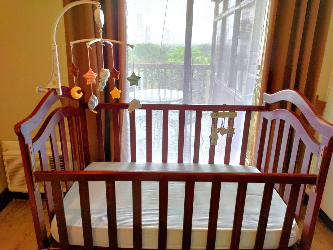 solid wood drop crib with free spring mattress and crib mobile on Carousell
