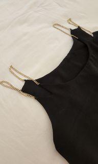 Black satin dress with gold chain detail.