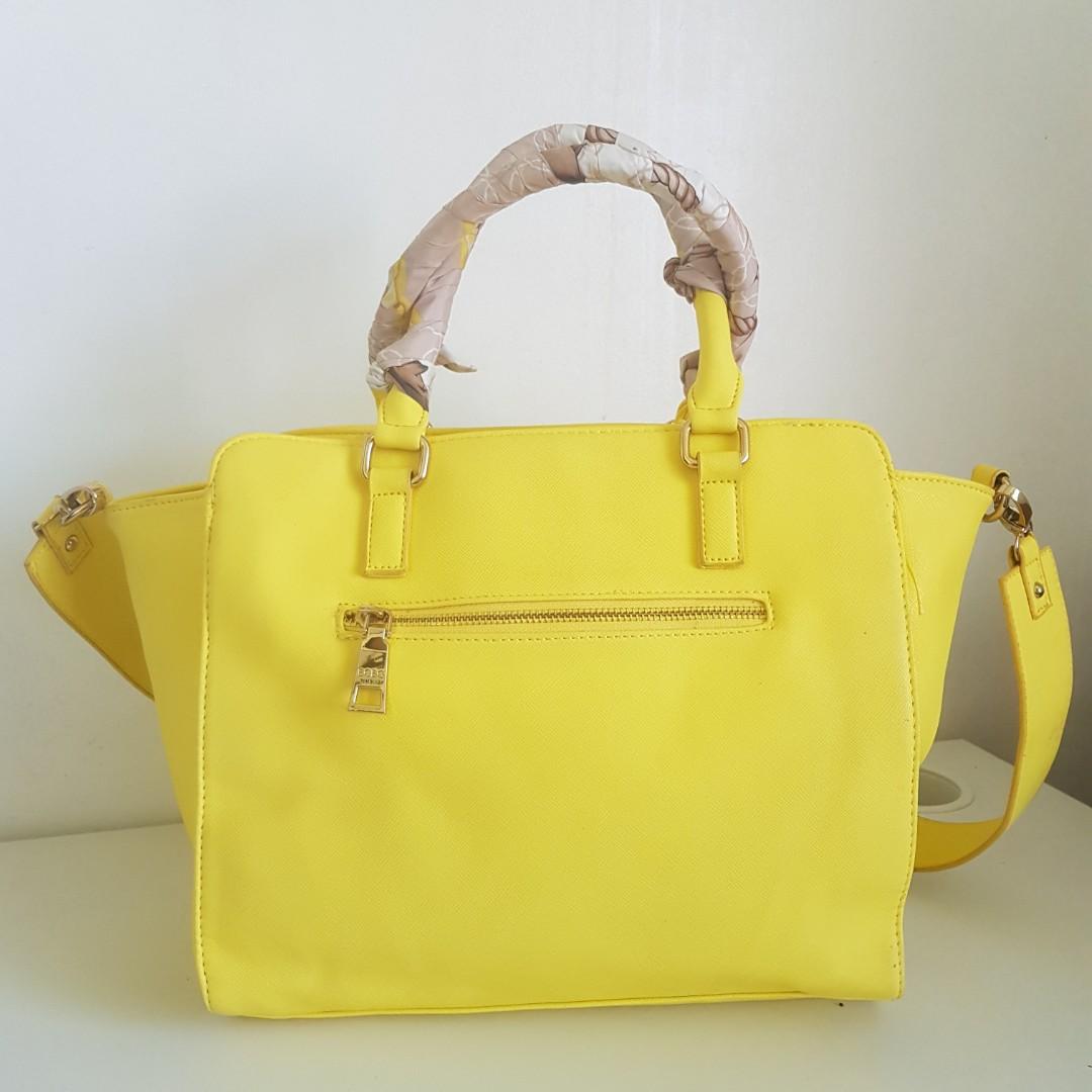 BCBG Yellow Leather Handbag (Category: Luxury Bags & Wallets) located in Quezon City. Submitted by maggieswardrobe (Listing ID 1158228611, Image 2). Description: --saffiano leather --detachable shoulder strap --all zippers in good condition --inner cloth lining is clean --issue: has a small brown spot in front (not sure if can be removed).