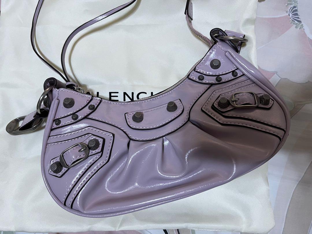 Balenciaga Le Cagole (Category: Luxury Bags & Wallets) located in Munoz. Submitted by mrsangelica (Listing ID 1166720210, Image 1). Description: Le Cagole XS Shoulder Bag in lavender Arena lambskin, aged silver hardware Dimensions : L10,2 x H6,3 x W2,7 inch • Arena lambskin • Shoulder bag • Adjustable shoulder strap (18,1 inch) • Leather braided shoulder pad • Zipped closure with knotted leather puller • Aged silver hardware • 1 removable zipped 