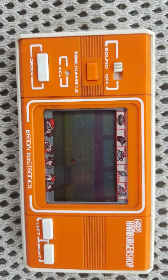 Vintage Handheld Gaming Console (Category: Others) located in Binangonan. Submitted by stufflikedat (Listing ID 1166975005, Image 3). Description: Vintage handheld gaming console 1.BANDAI BAKUDAN MAN (black) Japan 1980s in good working condition, 2 cell batt needed SOLD! 2.BANDAI HAMBURGER SHOP (orange) Japan 1980s in good working condition, 2 cell batt needed SOLD! 3.FINGER DANCE (red orange) in good working condition, 2xAA batt needed for 800 4