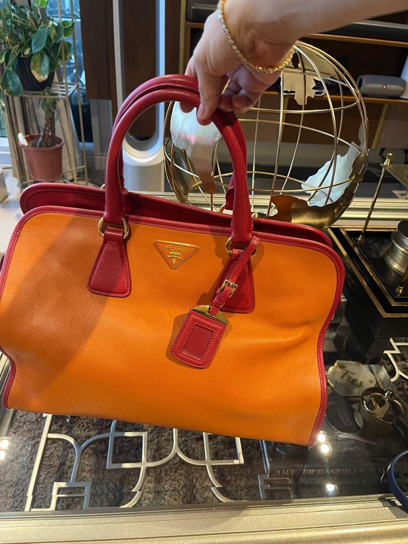 Prada Leather Bag (Category: Luxury Bags & Wallets) located in Makati City. Submitted by kl080808 (Listing ID 1173495843, Image 1). Description: The Prada Papaya (with red accent) in Saffiano Leather Dome Bag BN2575 is one chic and luxurious piece. This bag opens with a gold zip closure and has double rolled leather top handles. This bag is light weight vs my Birkin 35 with almost the same size. This bag comes with a luggage tag, padlock, keys, a