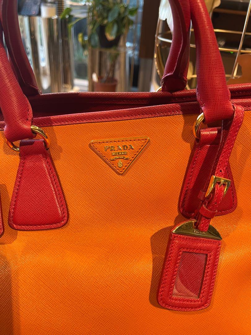 Prada Leather Bag (Category: Luxury Bags & Wallets) located in Makati City. Submitted by kl080808 (Listing ID 1173495843, Image 2). Description: The Prada Papaya (with red accent) in Saffiano Leather Dome Bag BN2575 is one chic and luxurious piece. This bag opens with a gold zip closure and has double rolled leather top handles. This bag is light weight vs my Birkin 35 with almost the same size. This bag comes with a luggage tag, padlock, keys, a