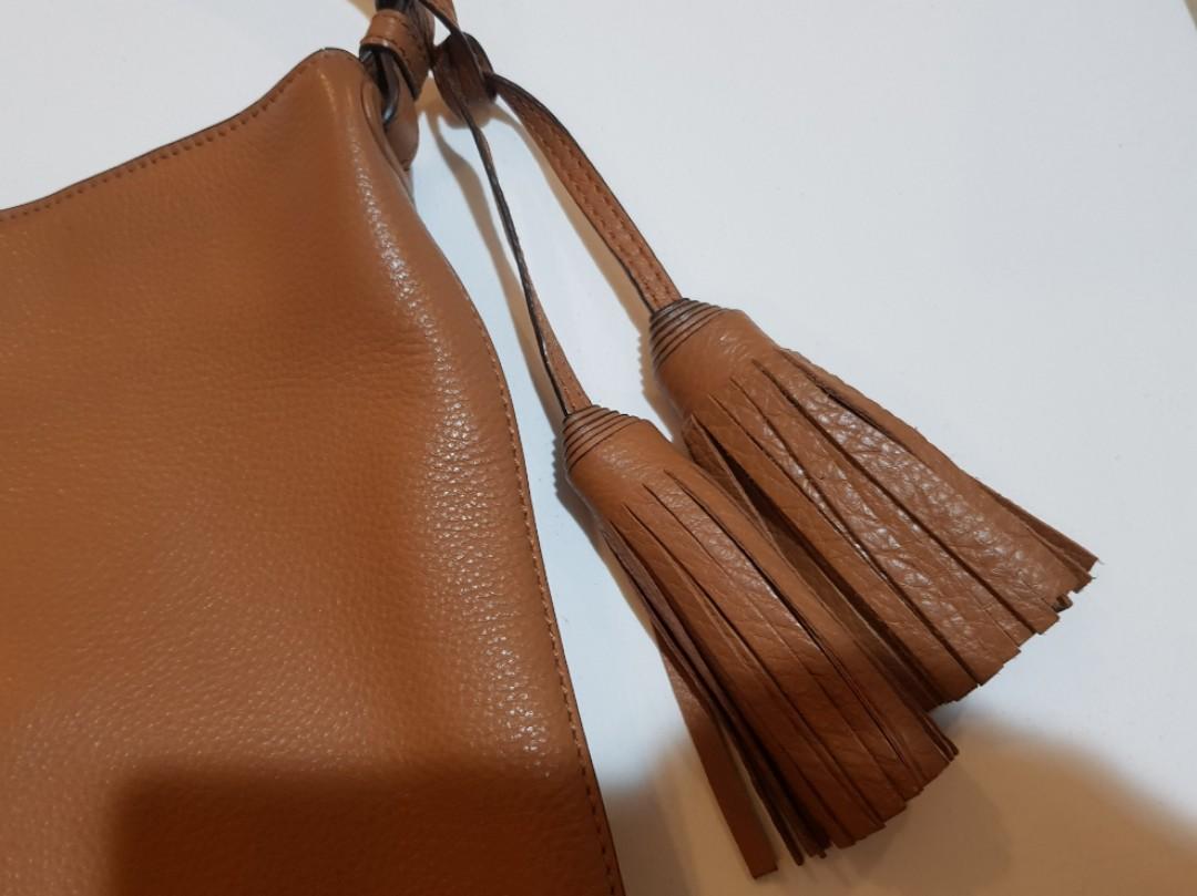Original/authentic Tory Burch Thea Hobo (Category: Luxury Bags & Wallets) located in Makati City. Submitted by B_man (Listing ID 1174240734, Image 3). Description: Leather Hobo Handbag. Dimensions:approx 10.5 in (H) x 15.5in (L) x 5.5in (bottom W). with a magnetic snap closure, an interior zip pocket, two exterior slip pockets, one buttoned interiorpocket and decorative tassels..